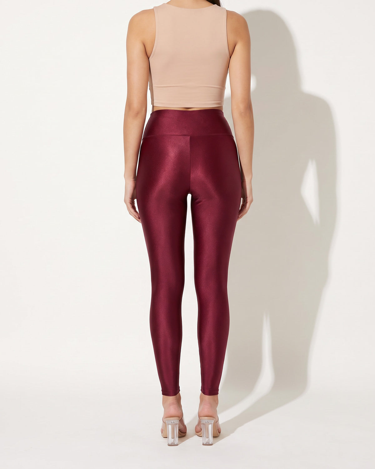 Burgundy shiny tricot leggings, back view on model