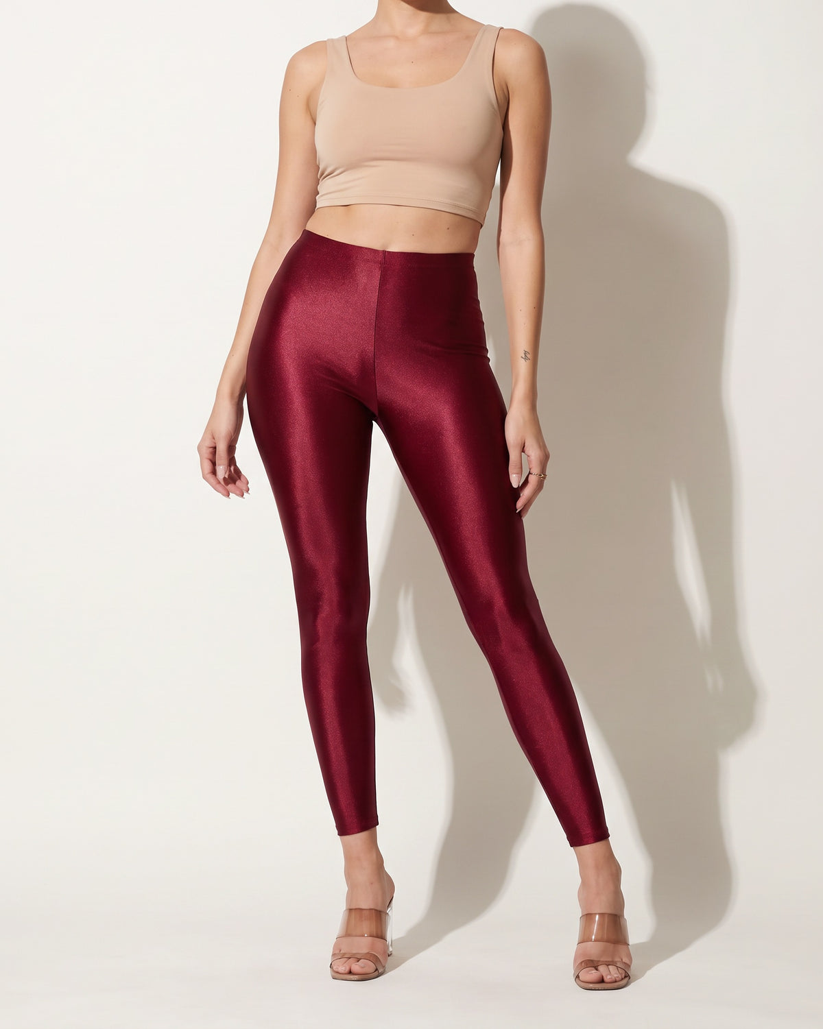 Burgundy shiny tricot leggings, front view on model