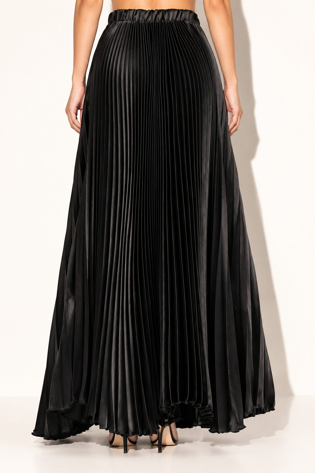 Black pleated satin maxi skirt, rear view showing gathered waistband and continuous fine pleats