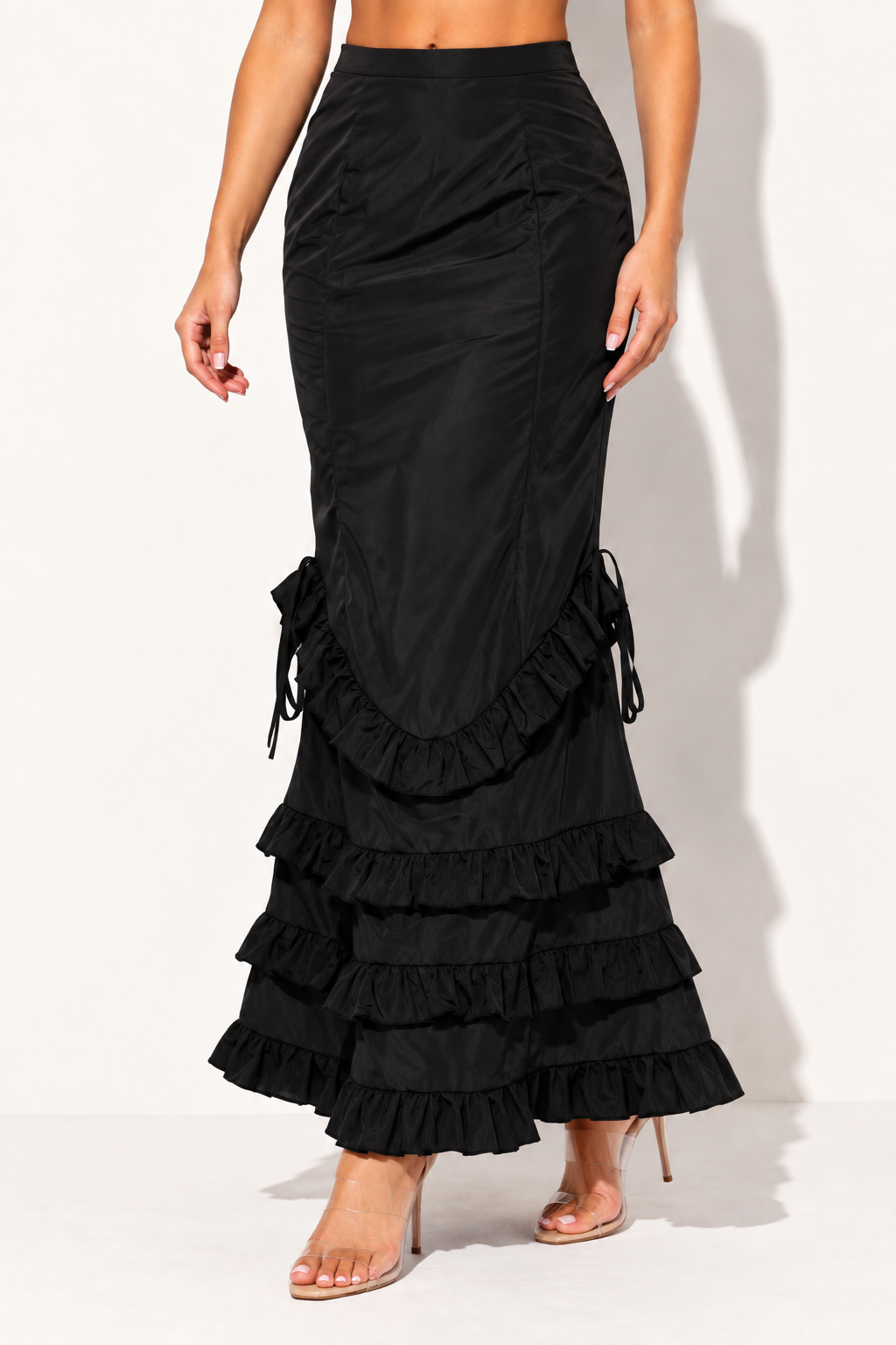 Black ruffle maxi skirt, angled front view showing fitted upper skirt and side ties