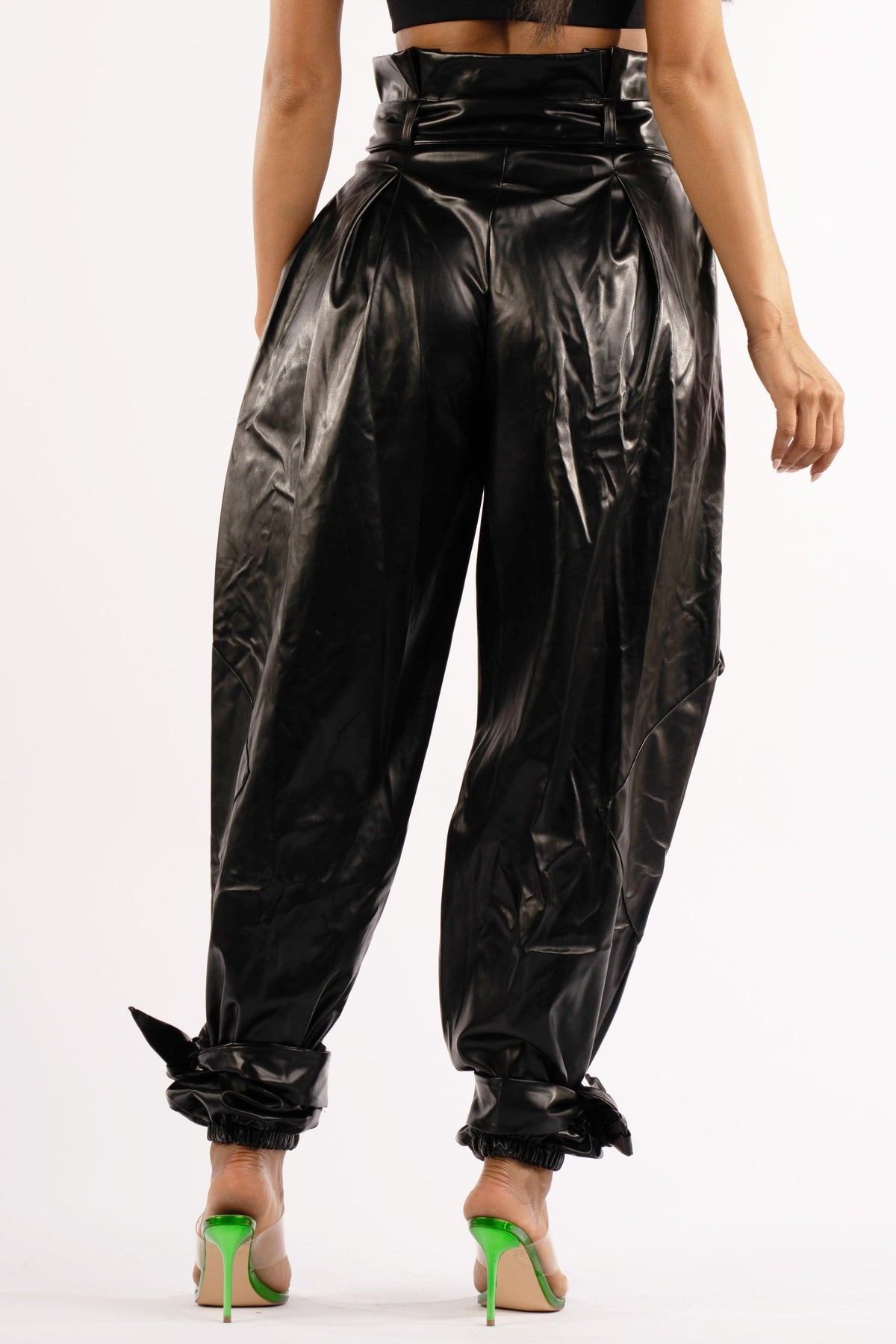 Black metallic PU jogger pants, side view on model