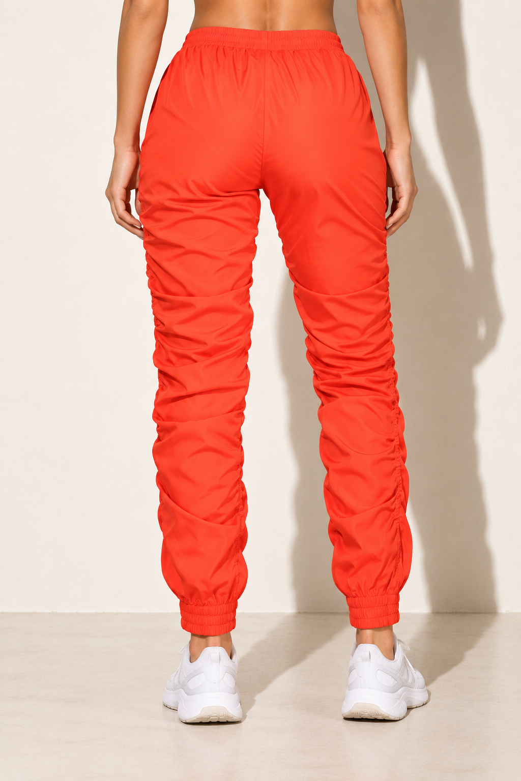 Orange ruched windbreaker jogger pants, back view