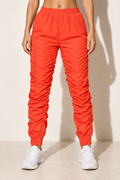 Muvin women's orange ruched windbreaker jogger pants, front view