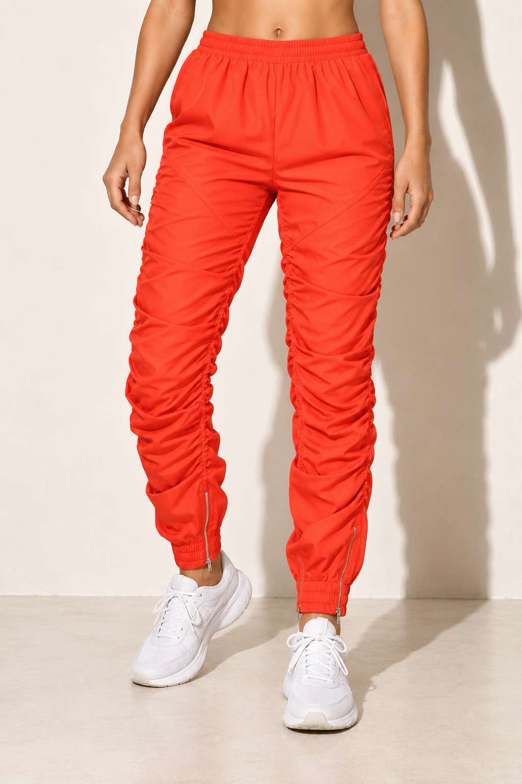 Orange ruched windbreaker jogger pants, alternate front view