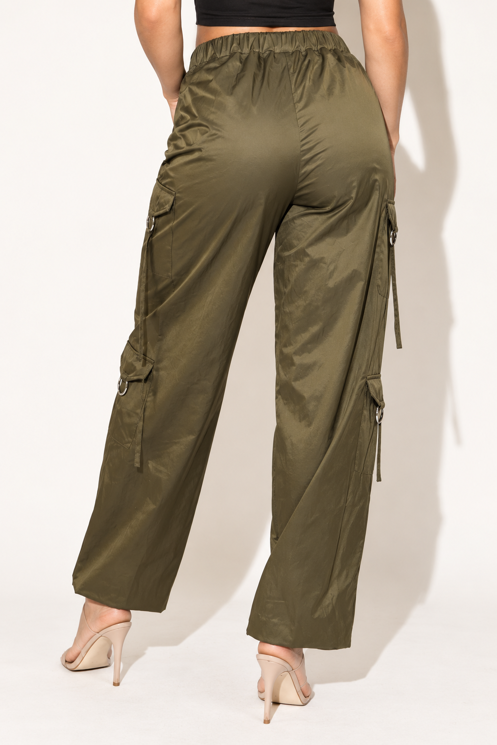 Olive windbreaker cargo pants with reflective trim, rear view showing elastic back waistband and ring-trimmed side pockets