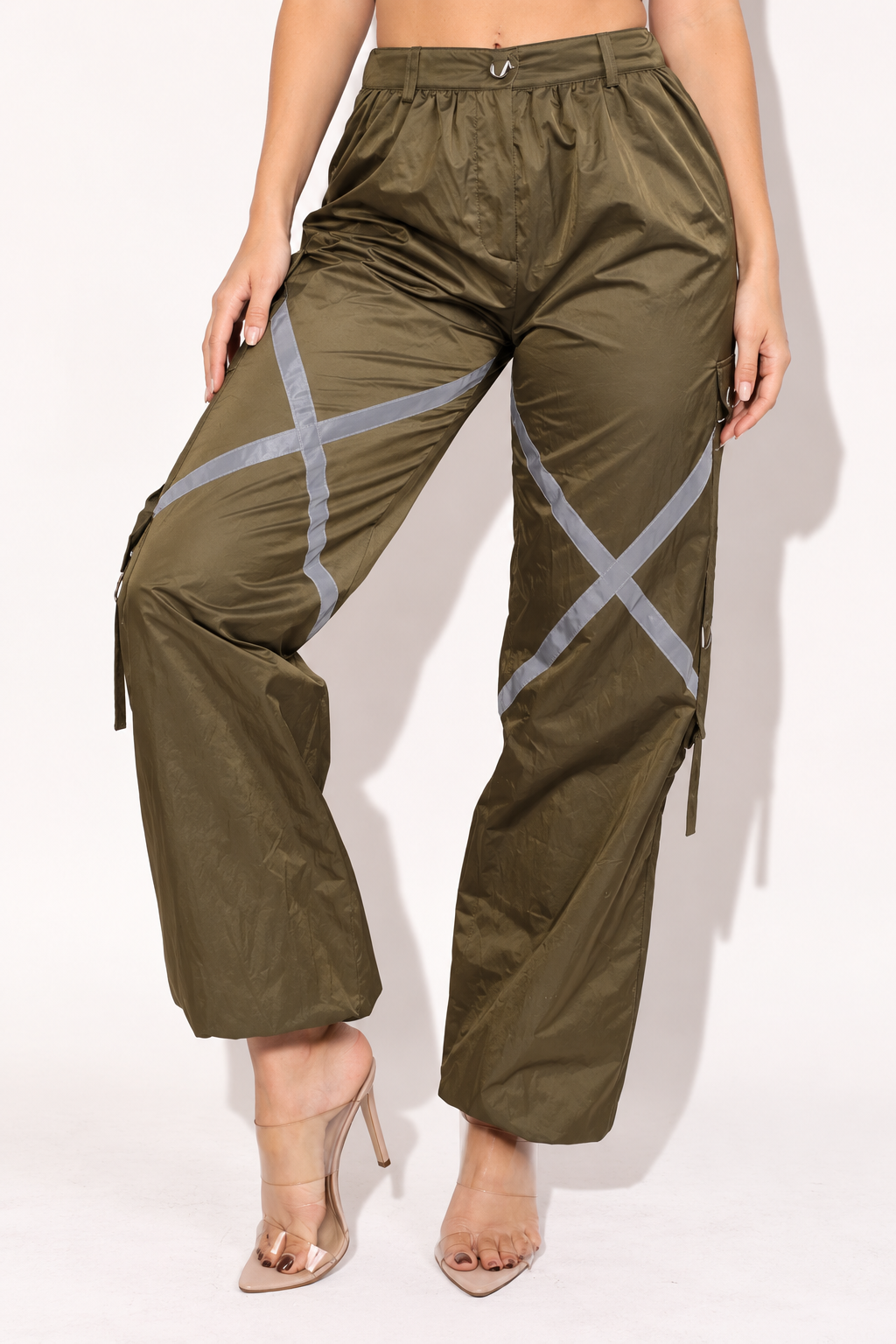 Olive windbreaker cargo pants with reflective trim, front angled view showing relaxed legs and cargo pocket straps