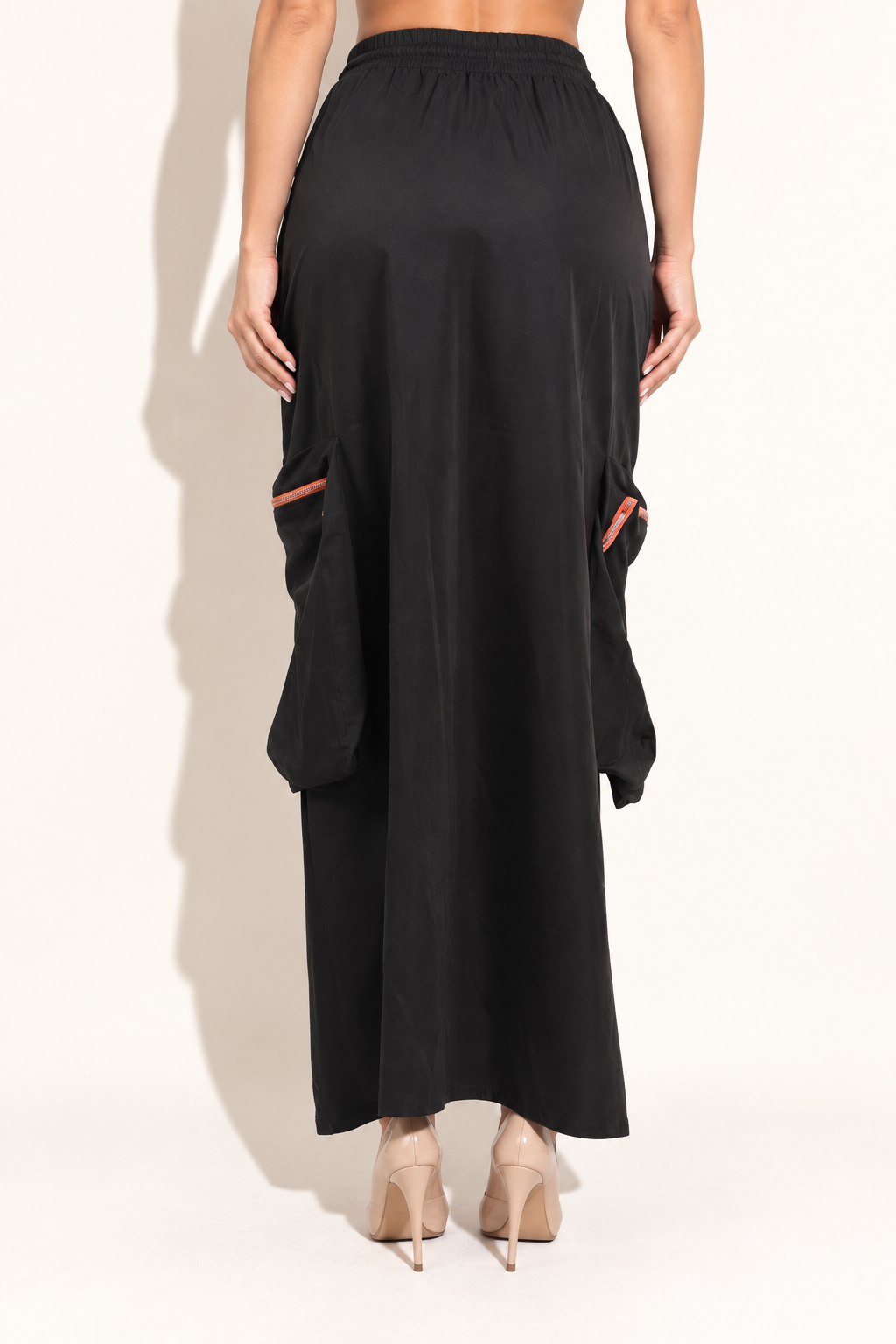 Black drawstring cargo maxi skirt with orange zippers, rear view showing plain black back and side cargo pockets