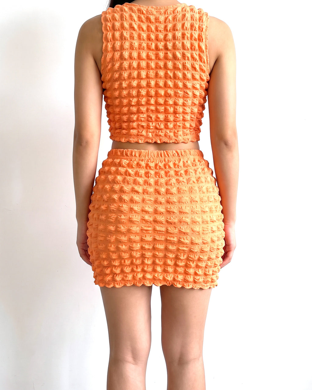 Orange popcorn mini skirt set, back view on model