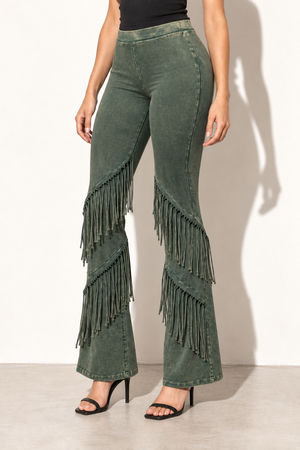 Olive mineral washed fringe flare pants, angled front view showing fitted upper legs and flared hems