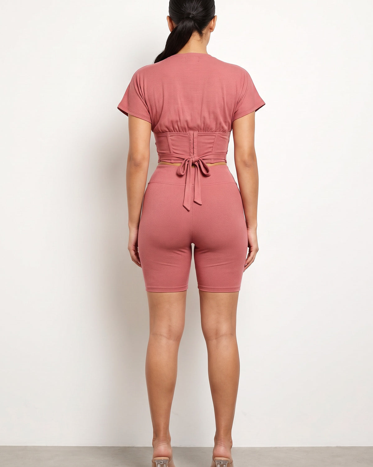 Mauve corseted top and biker set, back view on model