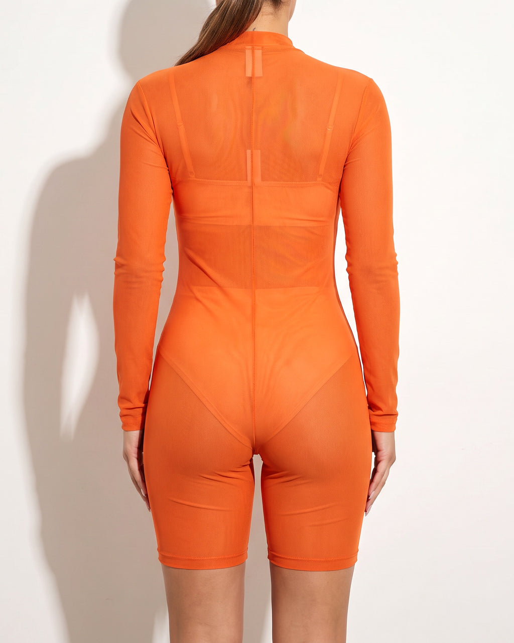 Orange mesh long sleeve zip up romper, back view on model