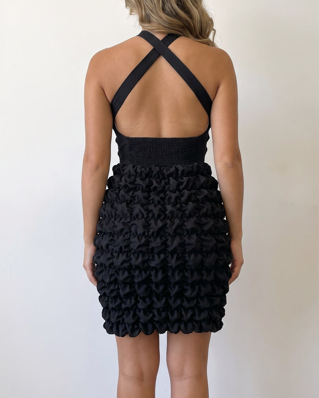 Black crinkled skirt halter dress, back view on model