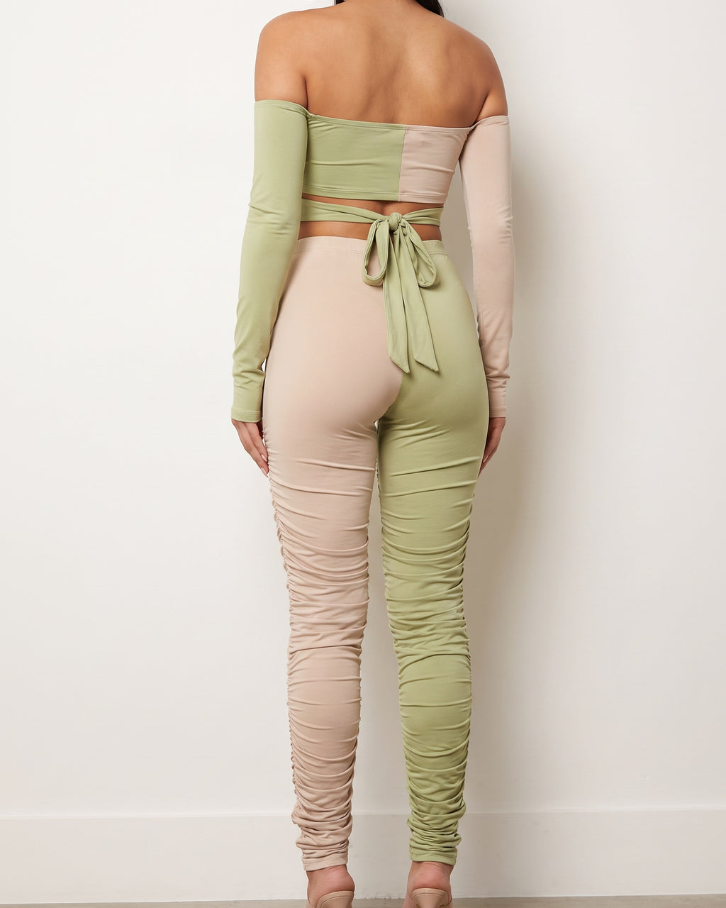 Nude and sage color blocked ruched set, back view on model