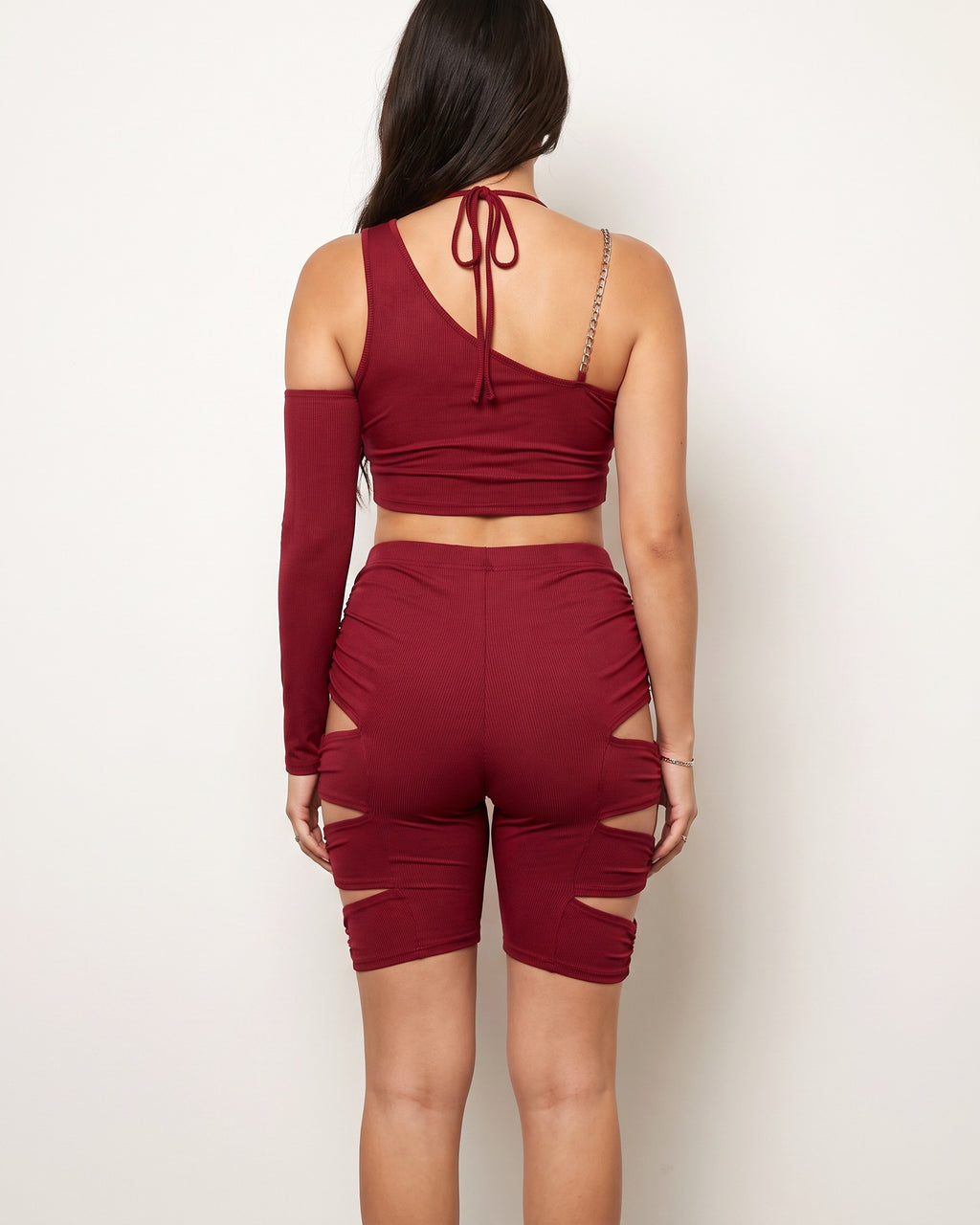 Burgundy cutout detailed asymmetric top set, back view on model