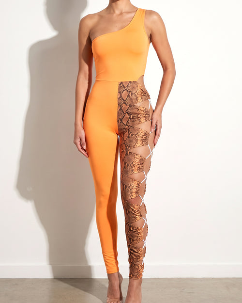 Orange asymmetric shoulder cut out jumpsuit, alternate front view on model