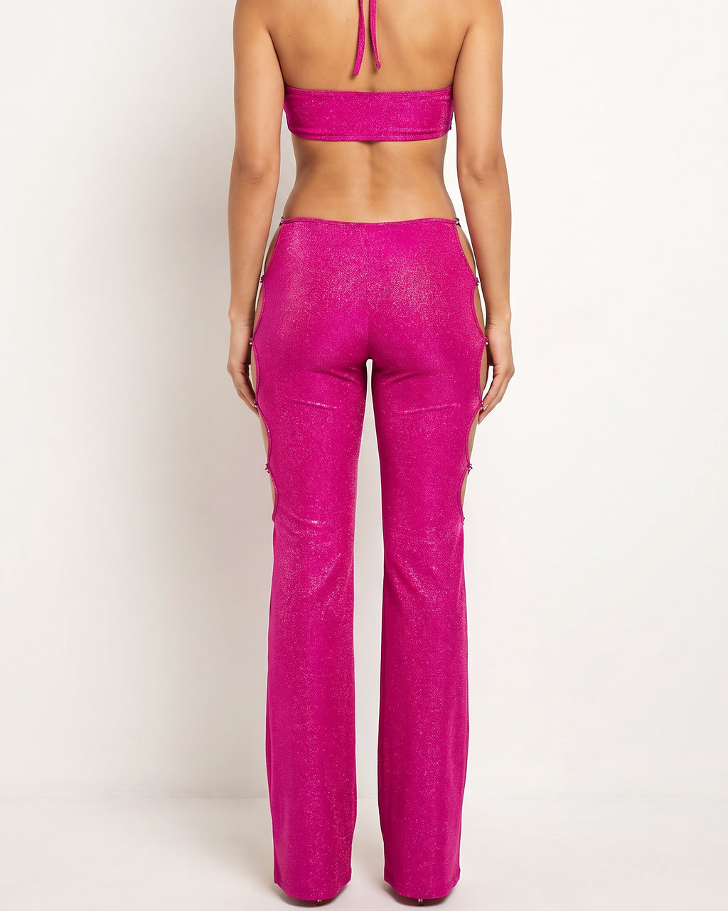Fucshia and gold glittery cutout halter neck keyhole jumpsuit, back view on model