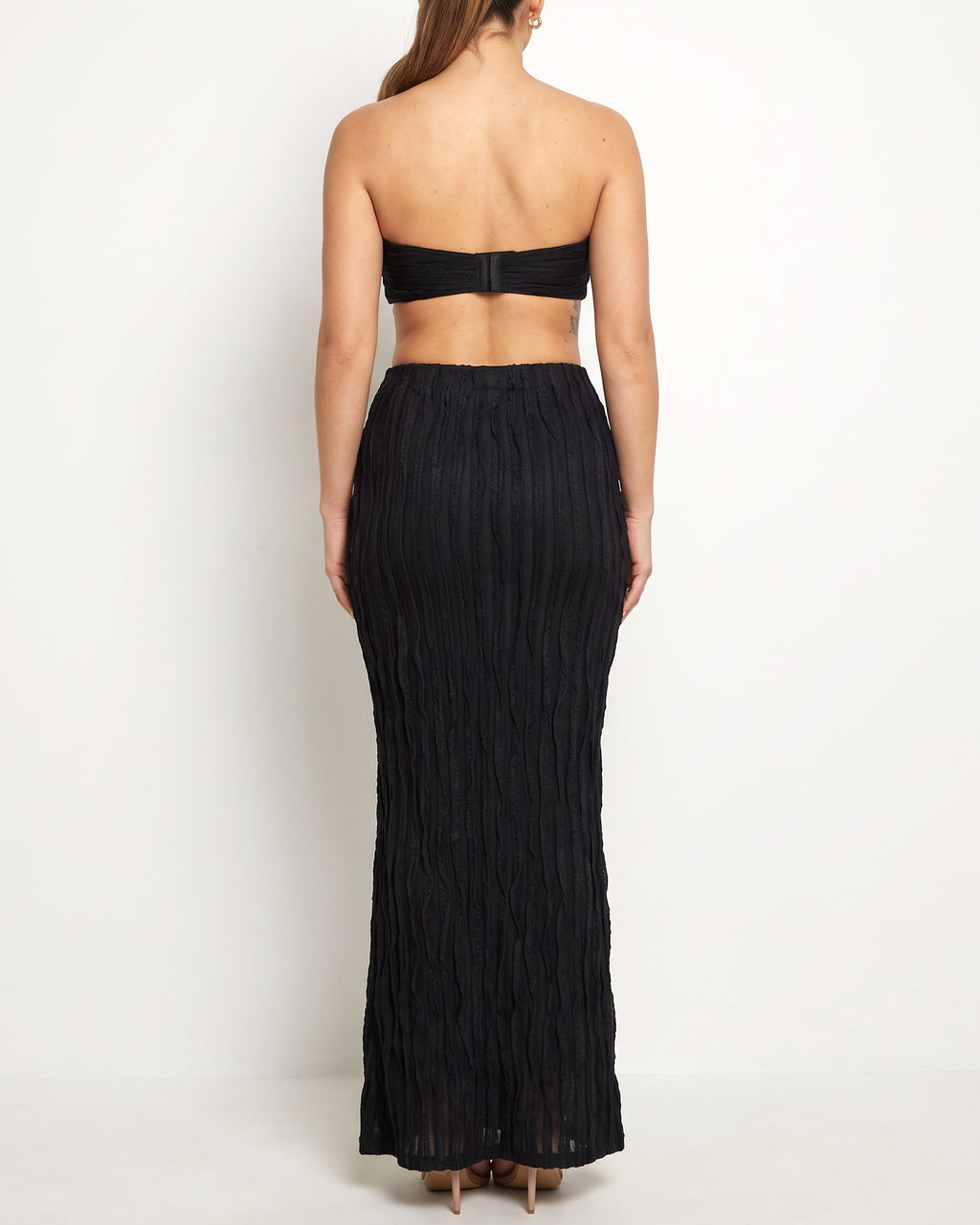 Black ruffle designed skirt set, back view on model