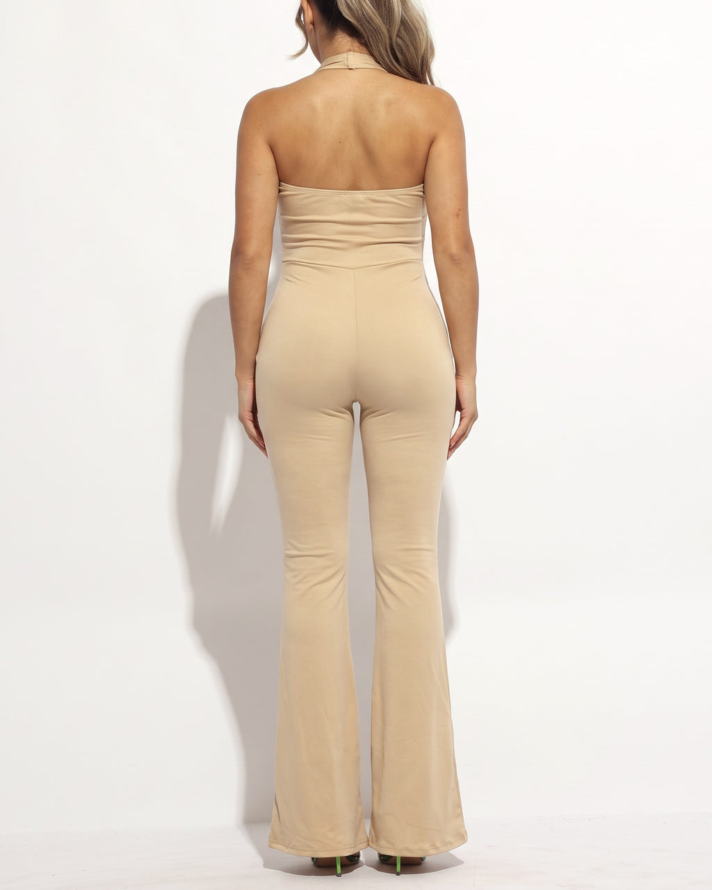 Nude halter deep V neck flare jumpsuit, back view on model