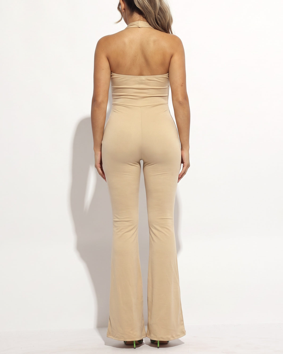 Nude halter deep V neck flare jumpsuit, back view on model