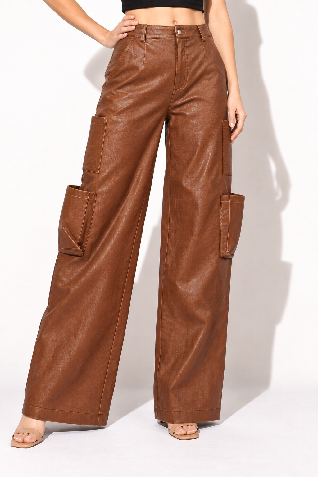 Brown faux leather wide leg utility pants, angled front view showing large knee pouches and wide legs