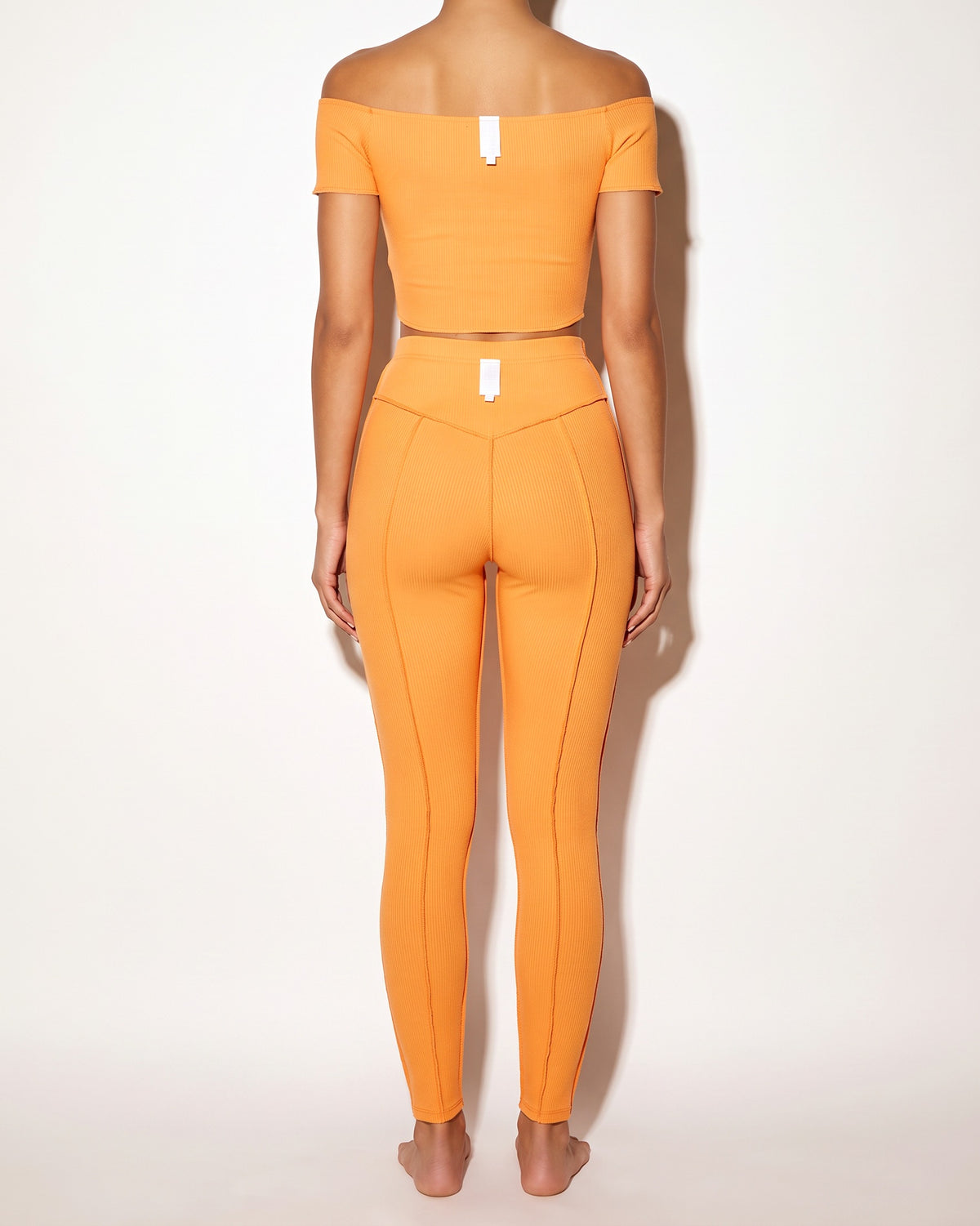 Orange ribbed set with reverse overlock stitch detail, back view on model