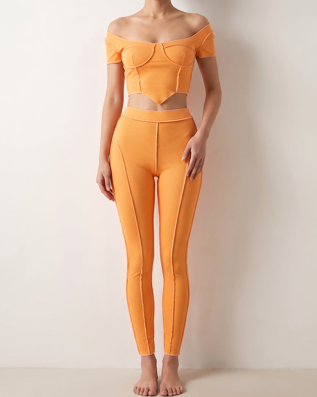 Orange ribbed set with reverse overlock stitch detail, alternate front view on model