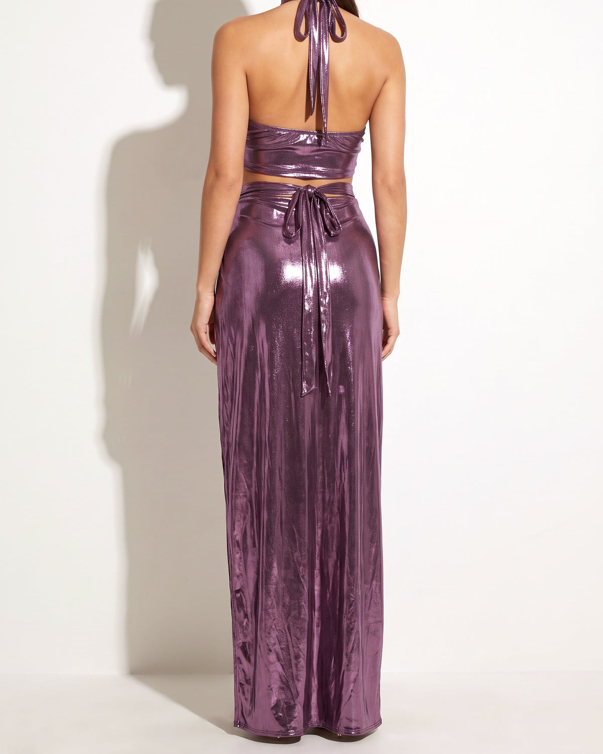 Purple foil surplice halter top and opened maxi skirt, back view on model